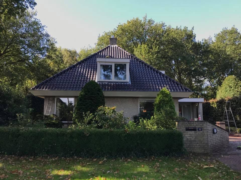 Woning met nieuw pannendak en dakkapellen, de bus van Maesam Dak ervoor